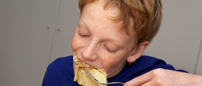 Jongen eet pannenkoek