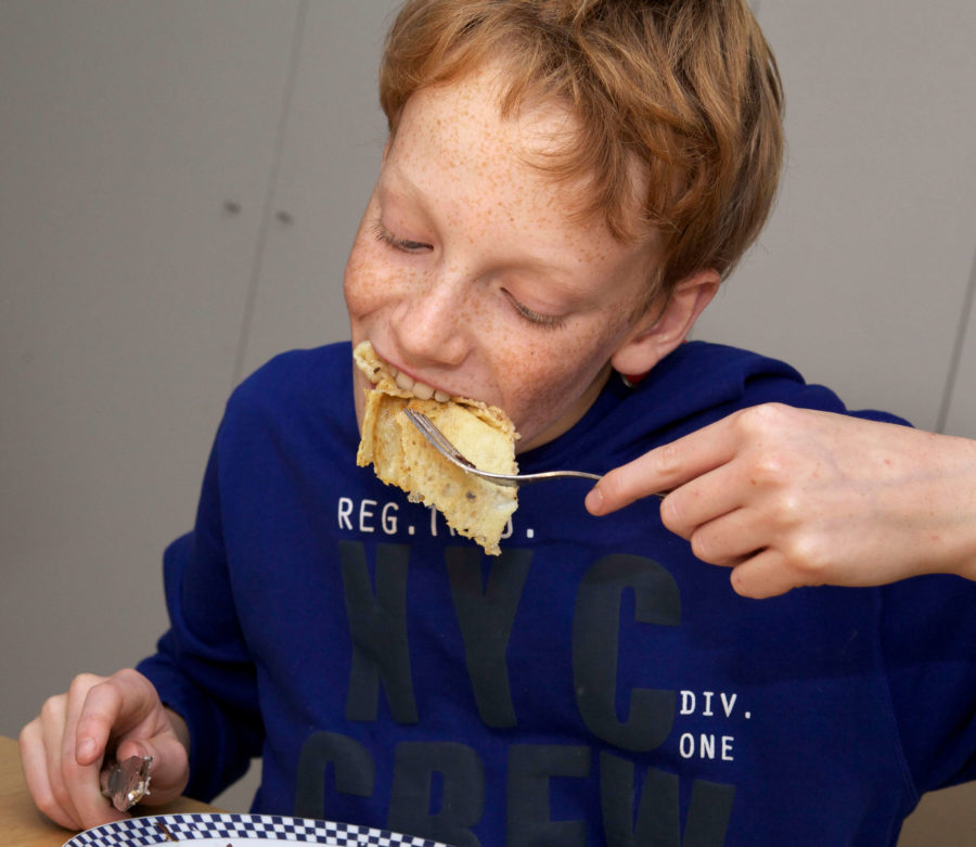 Jongen eet pannenkoek